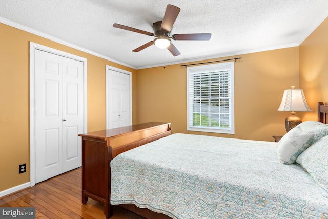 3 Cove Ct, Stafford, VA 22554 - bedroom featuring hardwood / wood-style floors, a textured ceiling, two closets, baseboards, and ornamental molding