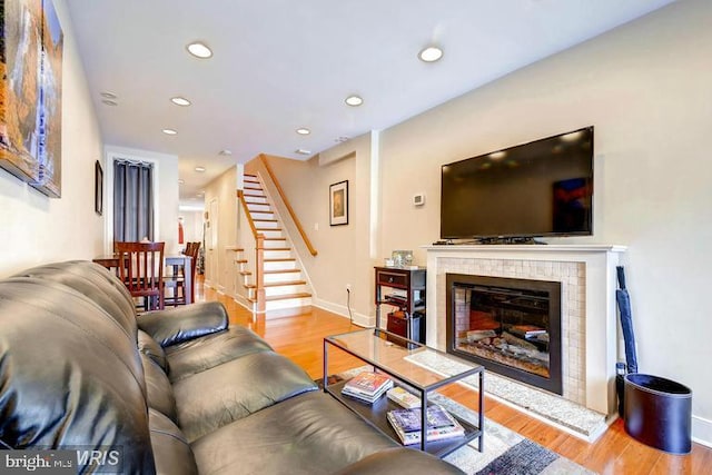608 S Washington St, Baltimore, MD 21231 - living room featuring stairway, wood finished floors, baseboards, recessed lighting, and a tile fireplace