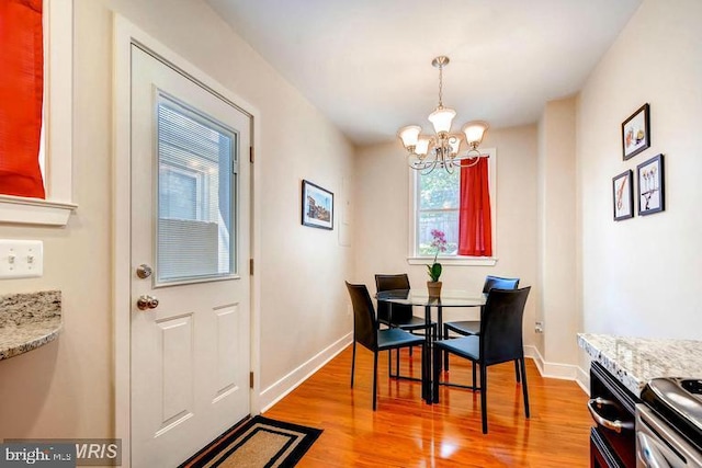 608 S Washington St, Baltimore, MD 21231 - dining area with a chandelier, light wood-type flooring, and baseboards