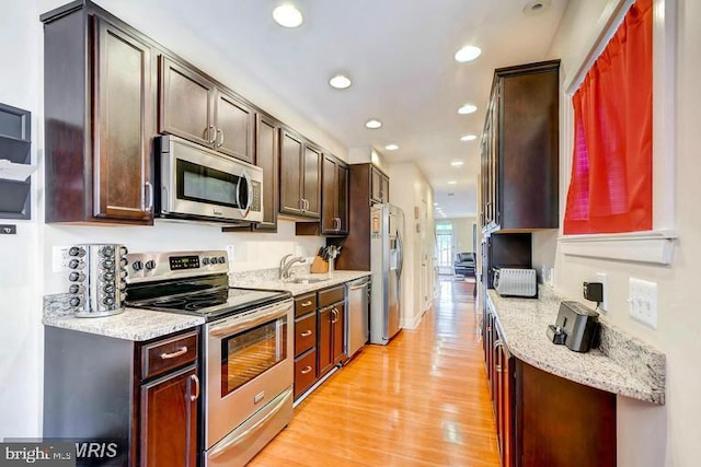 608 S Washington St, Baltimore, MD 21231 - kitchen featuring stainless steel appliances, a sink, light wood-style flooring, recessed lighting, and light stone countertops