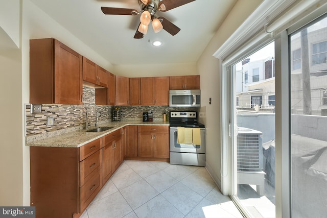 452 Fitzgerald St, Philadelphia, PA 19148 - kitchen with appliances with stainless steel finishes, backsplash, light stone counters, light tile patterned flooring, and ceiling fan