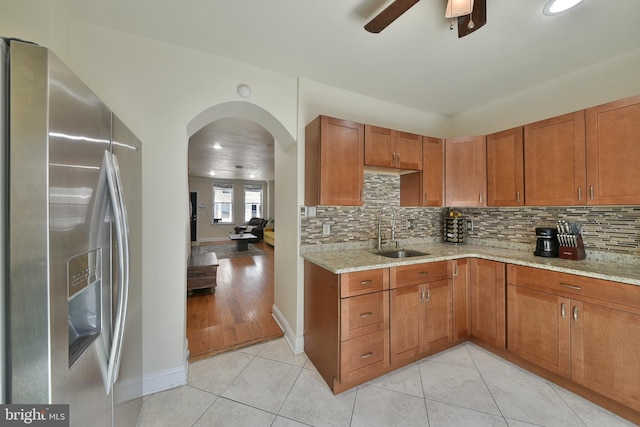 452 Fitzgerald St, Philadelphia, PA 19148 - kitchen with stainless steel fridge with ice dispenser, light stone counters, brown cabinetry, and recessed lighting