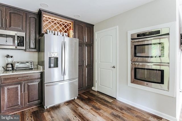 726 Harmony Orchard Rd, Front Royal, VA 22630 - kitchen with stainless steel appliances, dark brown cabinets, dark wood-style flooring, light stone countertops, and baseboards
