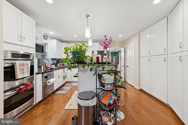 6625 Weatheford Ct, Mclean, VA 22101 - kitchen featuring appliances with stainless steel finishes, light wood-style floors, recessed lighting, white cabinetry, and hanging light fixtures