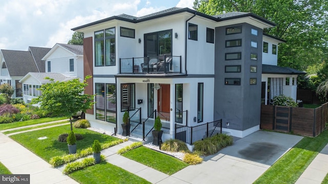 341 Hickman St, Rehoboth Beach, DE 19971 - contemporary house with a balcony, stucco siding, a porch, and a front lawn