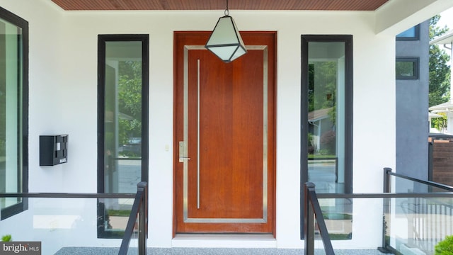 341 Hickman St, Rehoboth Beach, DE 19971 - doorway to property with stucco siding and a porch