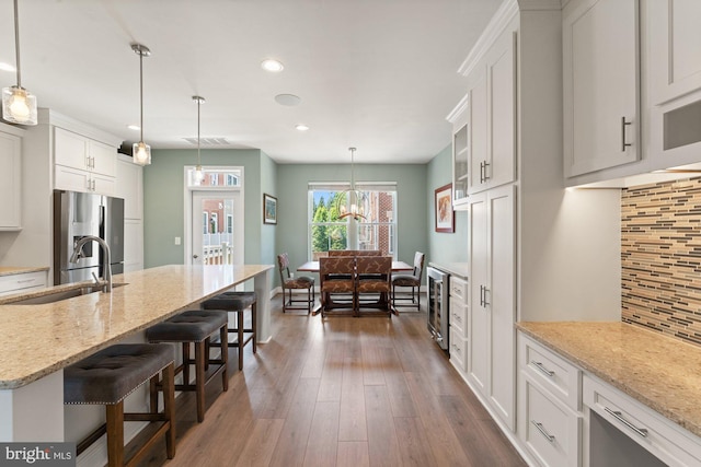 145 Center St S Unit 4, Vienna, VA 22180 - kitchen with stainless steel refrigerator with ice dispenser, a breakfast bar, white cabinets, recessed lighting, and a sink