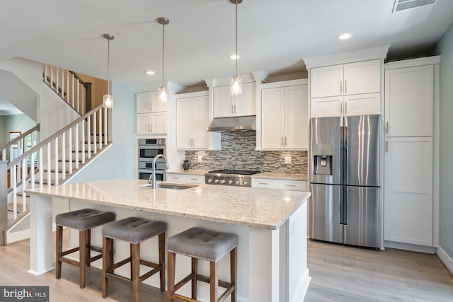 145 Center St S Unit 4, Vienna, VA 22180 - kitchen featuring stainless steel appliances, under cabinet range hood, a sink, tasteful backsplash, and light wood-style floors