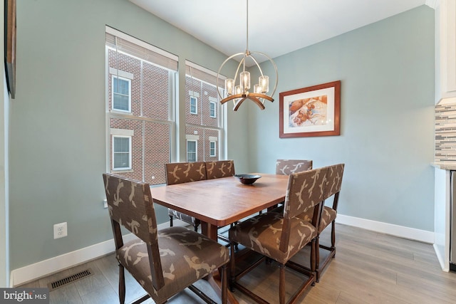 145 Center St S Unit 4, Vienna, VA 22180 - dining room with baseboards, light wood-style flooring, and a chandelier