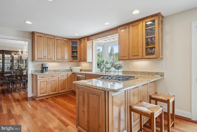 1028 Sandpiper Ln, Annapolis, MD 21403 - kitchen featuring stainless steel appliances, a peninsula, a sink, a kitchen bar, and light stone countertops