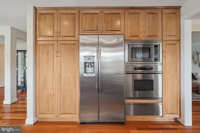 1028 Sandpiper Ln, Annapolis, MD 21403 - kitchen with stainless steel appliances, a warming drawer, light wood-style floors, and brown cabinetry
