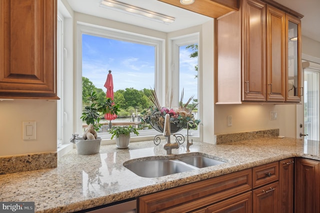 1028 Sandpiper Ln, Annapolis, MD 21403 - kitchen with glass insert cabinets, light stone countertops, and brown cabinetry