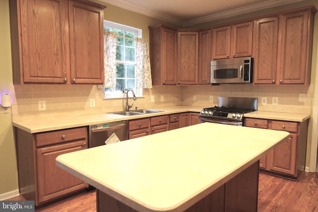 1207 Painted Fern Rd, Denton, MD 21629 - kitchen with stainless steel appliances, wood finished floors, light countertops, decorative backsplash, and crown molding