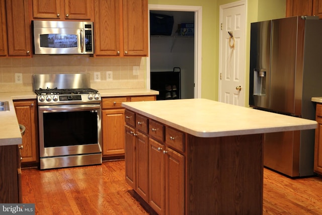 1207 Painted Fern Rd, Denton, MD 21629 - kitchen with appliances with stainless steel finishes, light countertops, light wood finished floors, and decorative backsplash
