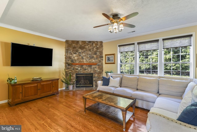 1207 Painted Fern Rd, Denton, MD 21629 - living area featuring ornamental molding, ceiling fan, light wood-style flooring, and a stone fireplace