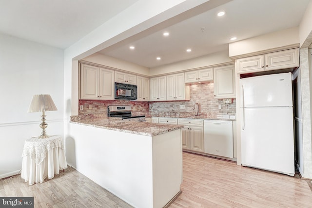 1 Smeton Place 506 & 606, Towson, MD 21204 - kitchen featuring white appliances, light wood-style flooring, decorative backsplash, light stone countertops, and recessed lighting