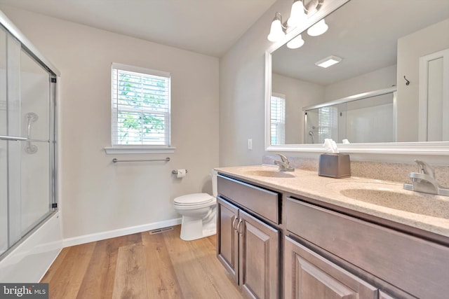 10 Hubbardton Ct, Sinking Spring, PA 19608 - bathroom featuring baseboards, double vanity, wood finished floors, toilet, and enclosed tub / shower combo