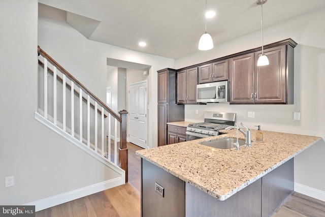 10 Hubbardton Ct, Sinking Spring, PA 19608 - kitchen with stainless steel appliances, a sink, light wood-type flooring, light stone counters, and baseboards