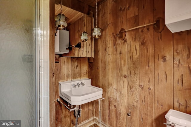 1415 Rockland St, Reading, PA 19604 - bathroom with wood walls, toilet, a shower with door, and a sink