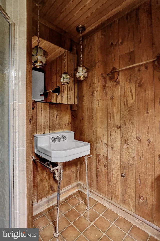 1415 Rockland St, Reading, PA 19604 - bathroom featuring wooden ceiling with exposed beams, wood walls, tile patterned flooring, a sink, and a shower with door