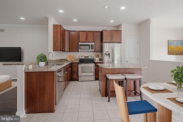 309 Latrobe Dr, Newark, DE 19702 - kitchen featuring stainless steel appliances, a sink, a kitchen bar, light stone countertops, and recessed lighting