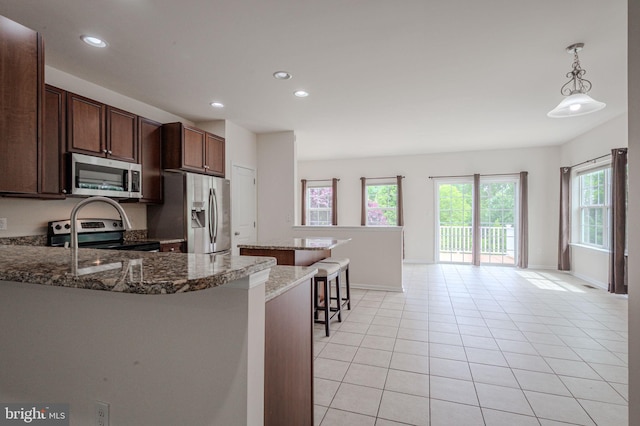 309 Latrobe Dr, Newark, DE 19702 - kitchen featuring appliances with stainless steel finishes, a breakfast bar, recessed lighting, light tile patterned floors, and baseboards