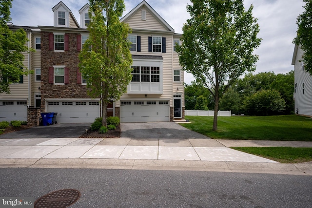 309 Latrobe Dr, Newark, DE 19702 - townhome / multi-family property with stone siding, a front yard, driveway, and a garage