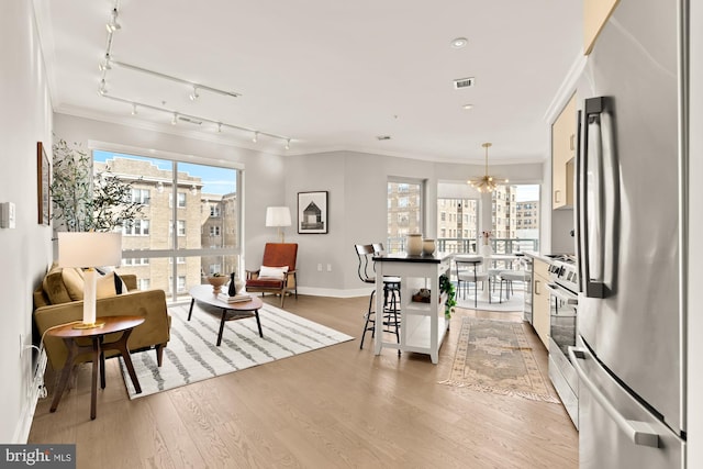 2550 17th St NW Unit 414, Washington, DC 20009 - living room with crown molding, track lighting, a chandelier, wood finished floors, and baseboards