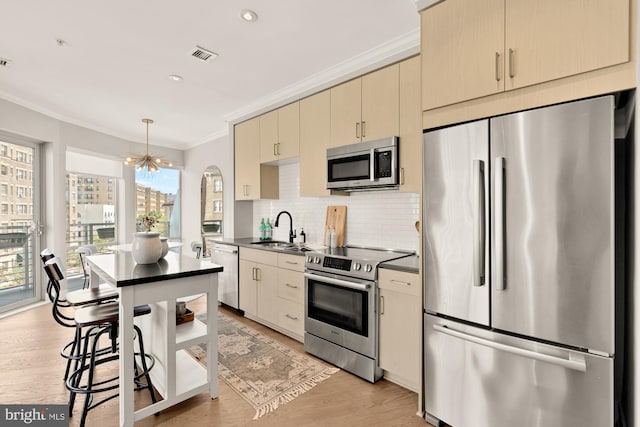 2550 17th St NW Unit 414, Washington, DC 20009 - kitchen with appliances with stainless steel finishes, a sink, dark countertops, crown molding, and backsplash