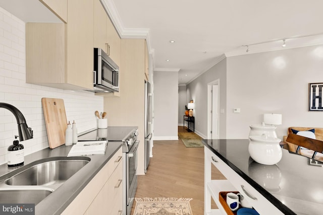 2550 17th St NW Unit 414, Washington, DC 20009 - kitchen with stainless steel appliances, a sink, dark countertops, crown molding, and light wood finished floors