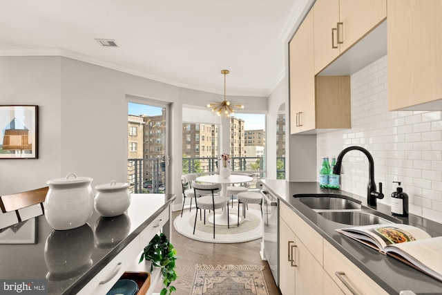 2550 17th St NW Unit 414, Washington, DC 20009 - kitchen with stainless steel dishwasher, tasteful backsplash, a sink, dark wood finished floors, and ornamental molding
