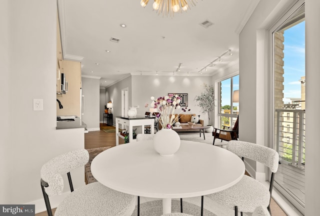 2550 17th St NW Unit 414, Washington, DC 20009 - dining room featuring crown molding, baseboards, rail lighting, wood finished floors, and recessed lighting