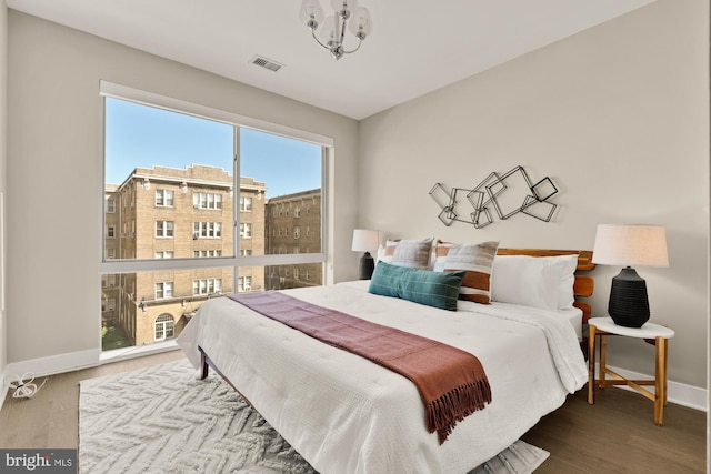 2550 17th St NW Unit 414, Washington, DC 20009 - bedroom with baseboards, wood finished floors, and a chandelier