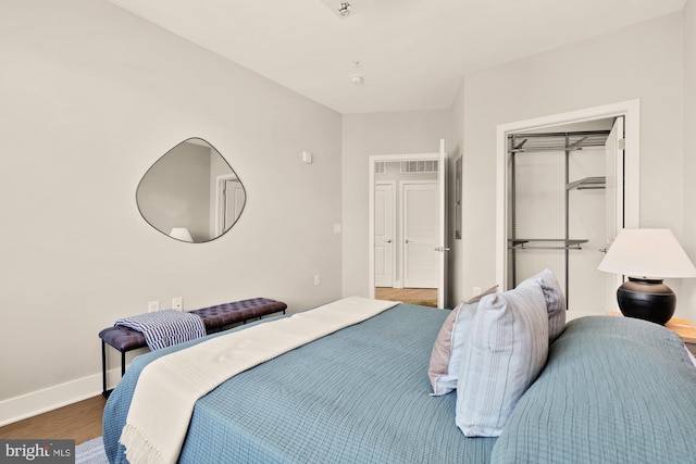 2550 17th St NW Unit 414, Washington, DC 20009 - bedroom with a closet, baseboards, and wood finished floors
