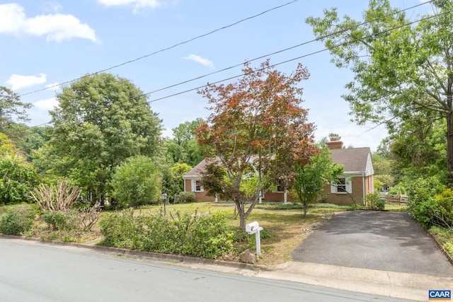 104 Chaucer Rd, Charlottesville, VA 22901 - view of property hidden behind natural elements with asphalt driveway, a chimney, and brick siding