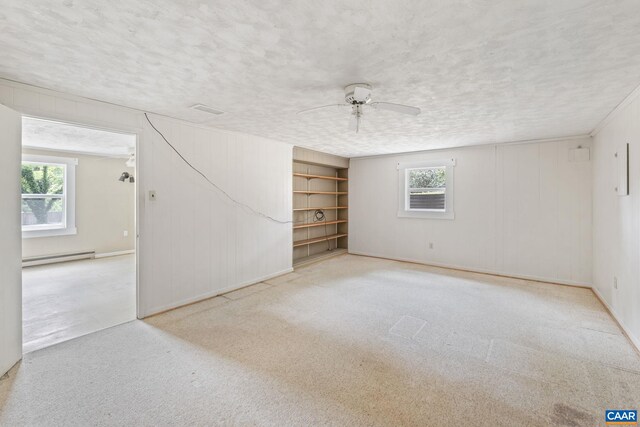 104 Chaucer Rd, Charlottesville, VA 22901 - carpeted spare room with healthy amount of natural light, a baseboard heating unit, ceiling fan, a textured ceiling, and wooden walls