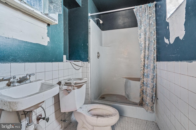 3310 E Lombard St, Baltimore, MD 21224 - full bathroom featuring tile walls, a shower stall, toilet, tile patterned floors, and wainscoting