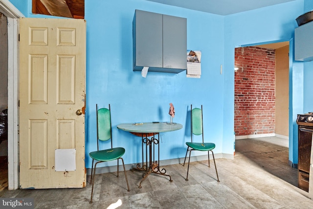 3310 E Lombard St, Baltimore, MD 21224 - dining area featuring baseboards and brick wall