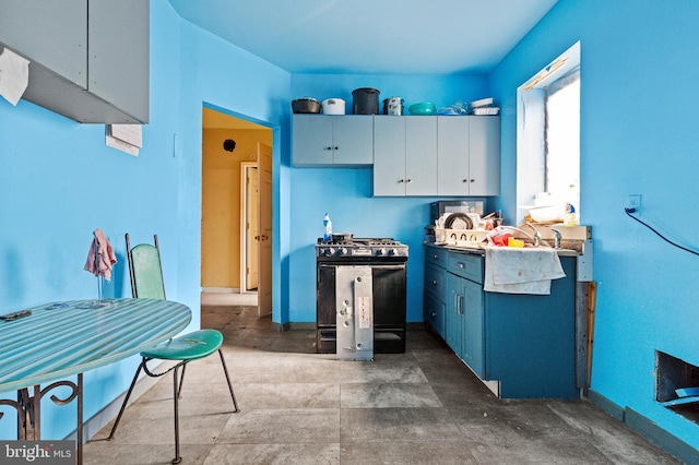 3310 E Lombard St, Baltimore, MD 21224 - kitchen with gas stove, blue cabinets, white cabinets, and baseboards