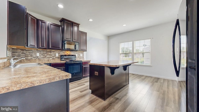 637 Coldwater Dr, Clayton, DE 19938 - kitchen with black appliances, a sink, light countertops, backsplash, and light wood-style floors