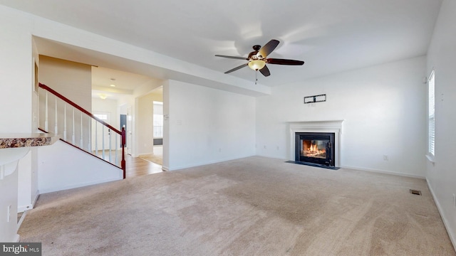 637 Coldwater Dr, Clayton, DE 19938 - unfurnished living room with a fireplace with flush hearth, carpet floors, ceiling fan, and stairway