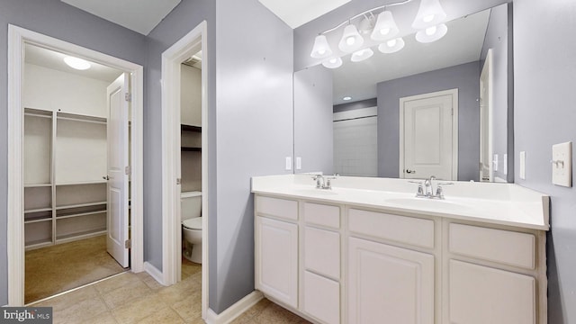 637 Coldwater Dr, Clayton, DE 19938 - bathroom with double vanity, toilet, baseboards, and a spacious closet