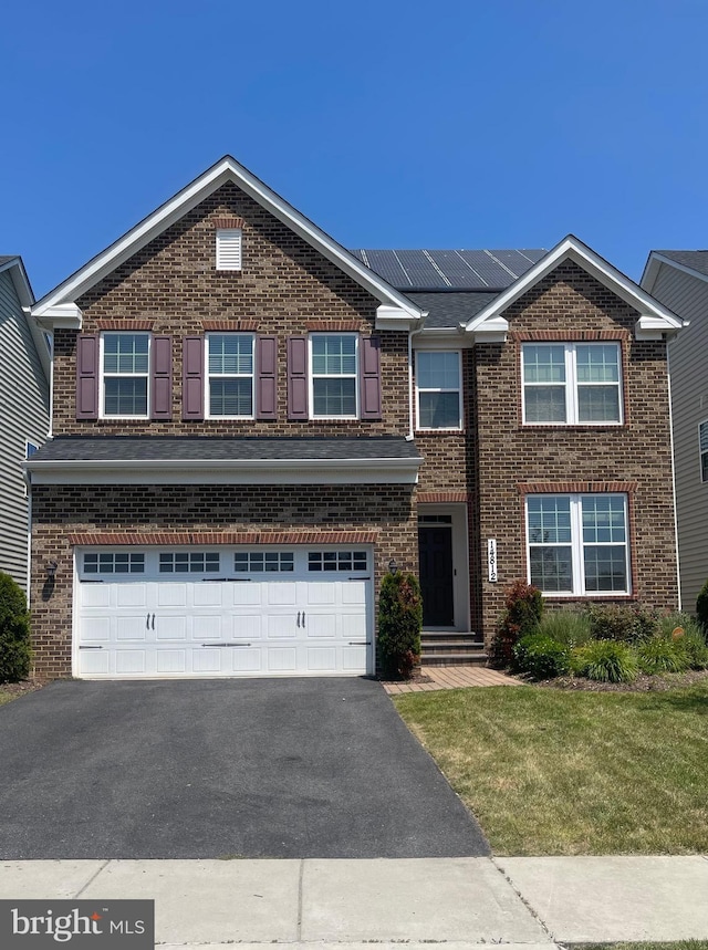 14812 Saddle Creek Dr, Burtonsville, MD 20866 - traditional-style house featuring asphalt driveway, a garage, brick siding, a front lawn, and roof mounted solar panels