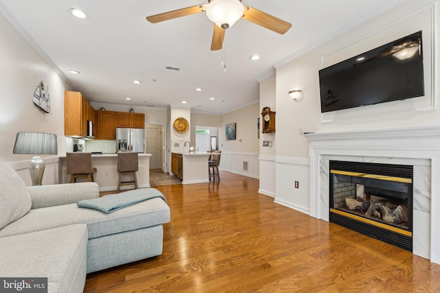 633 Ruxton Rd Unit 75, Solomons, MD 20688 - living area featuring ornamental molding, recessed lighting, light wood-type flooring, a ceiling fan, and a glass covered fireplace