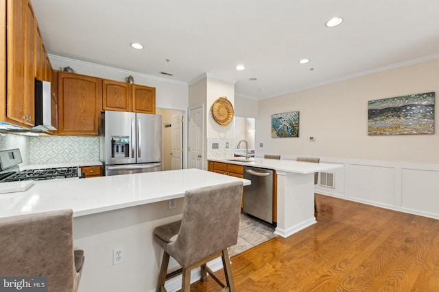 633 Ruxton Rd Unit 75, Solomons, MD 20688 - kitchen with stainless steel appliances, a peninsula, a sink, light countertops, and ornamental molding