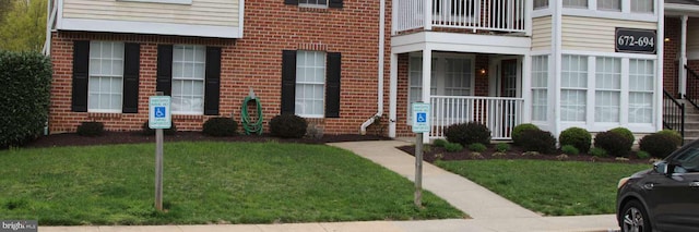 672 Jupiter Hills Ct, Arnold, MD 21012 - view of exterior entry with brick siding, a yard, and a balcony