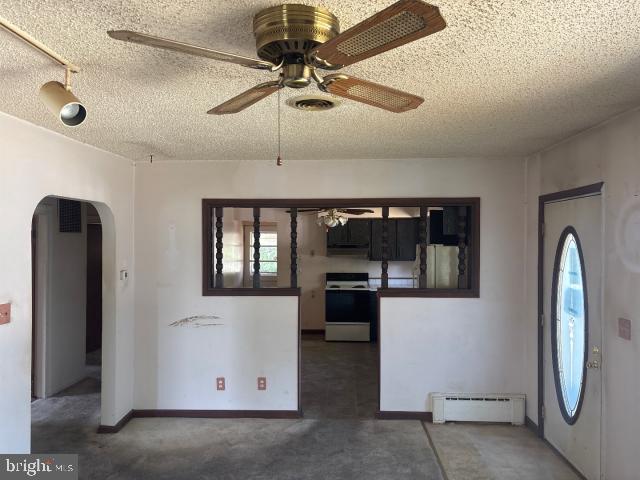 215 4th Ave, West Berlin, NJ 08091 - unfurnished dining area featuring a baseboard heating unit, ceiling fan, arched walkways, and a textured ceiling
