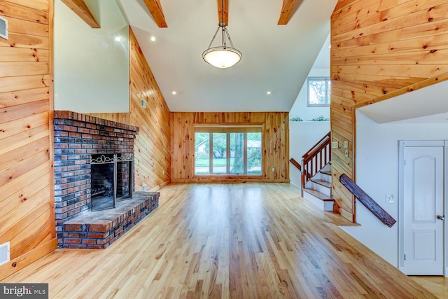 22 Slayback Dr, Princeton Junction, NJ 08550 - unfurnished living room featuring wooden walls, a brick fireplace, wood finished floors, stairway, and lofted ceiling