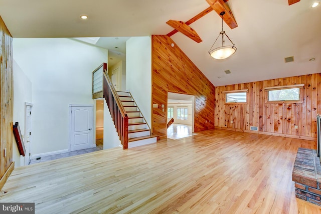 22 Slayback Dr, Princeton Junction, NJ 08550 - unfurnished living room with high vaulted ceiling, stairs, wooden walls, light wood-type flooring, and beamed ceiling