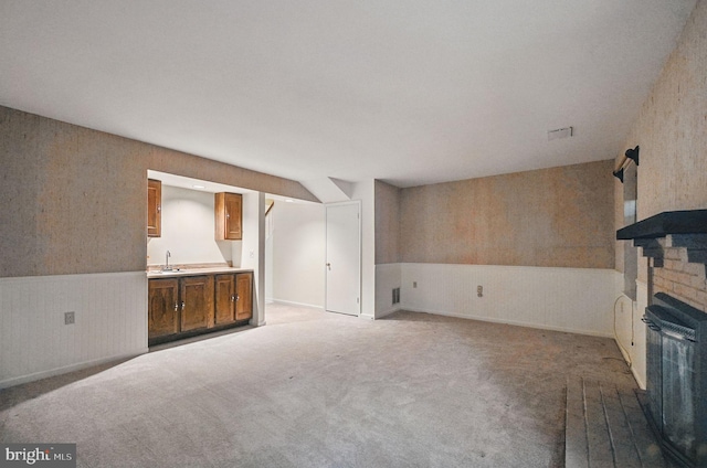 11707 Critton Cir, Woodbridge, VA 22192 - unfurnished living room with carpet floors, a brick fireplace, a wainscoted wall, and wallpapered walls